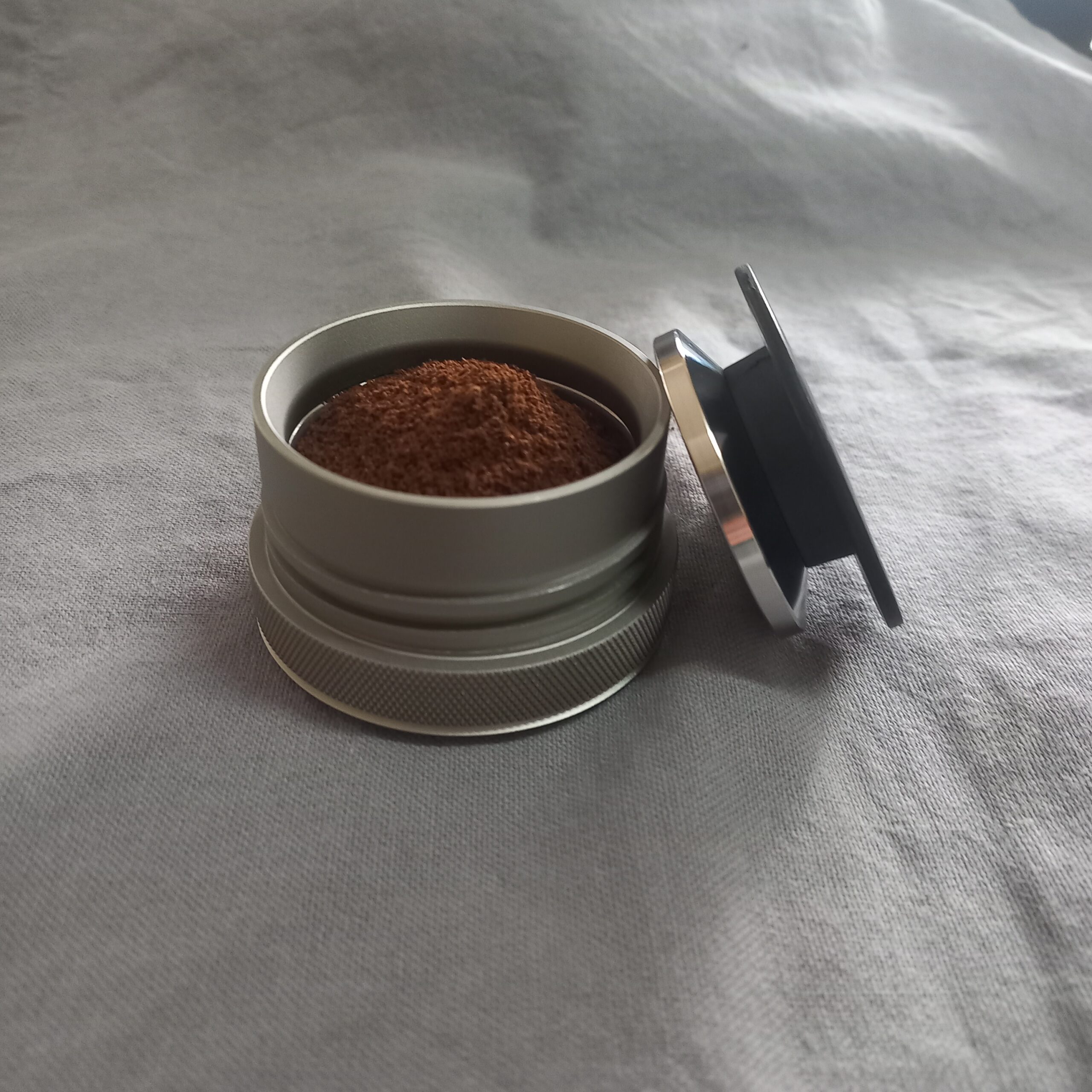 Coffee in coffee basket using funnel, and tamping Wacaco potable coffee maker